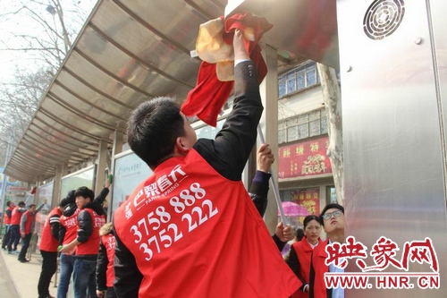 志愿者们在擦洗公交站亭